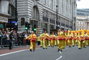 London New Year Parade, Ben Chen at front right and other Falun Gong practitioners play waist drums along with hundreds of other groups parading down Piccadilly. 